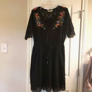 Embroidered dress with pockets and lace trim on bodice, sleeves, and hem